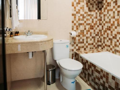 纳祖尔Hotel L'Aéroport的浴室配有卫生间、盥洗盆和浴缸。