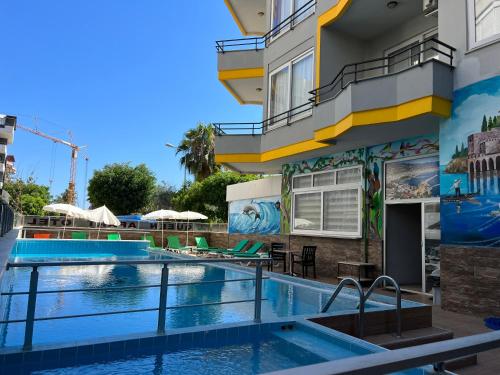 阿拉尼亚Alanya Queen Apart Otel的一座建筑一侧带有壁画的酒店游泳池