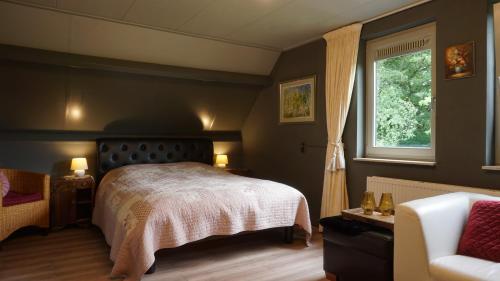Ter ApelB&B aan het bos的一间卧室设有床、窗户和沙发