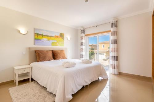 拉戈斯Boavista Golf & Spa - Bela Colina Village的卧室配有白色的床和窗户。
