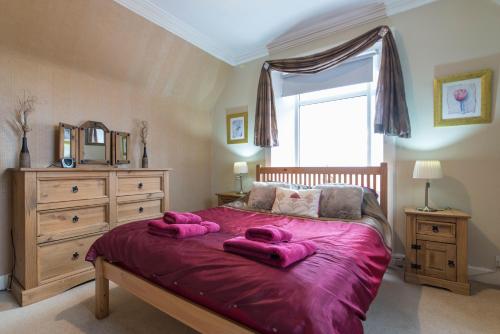 威克The Old School House - Cosy 3 bedroom Cottage的一间卧室配有一张大床,上面有粉红色的毛巾