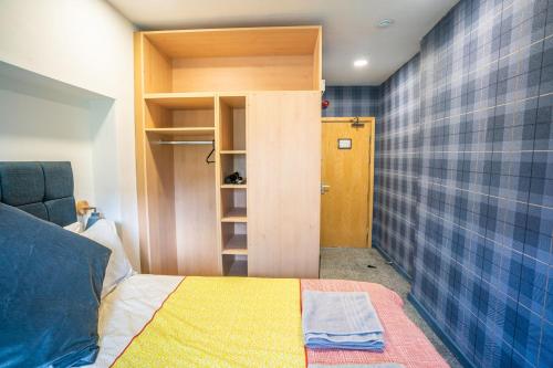 泰恩河畔纽卡斯尔Apartment Chinatown 306的小房间设有一张床和一个衣柜