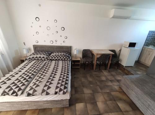 希欧福克Vasti Apartman的一间卧室配有一张床和一张桌子及椅子