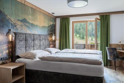 图克斯Berggasthaus Höllensteinhütte的卧室配有一张大床,墙上挂有绘画作品