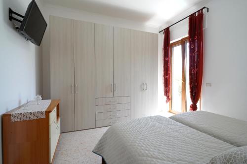 圣安吉洛Milou's House的一间卧室配有一张床、一个梳妆台和一扇窗户。