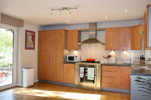 爱丁堡Luxflat - Port Of Leith - Free Parking的一间带木制橱柜和微波炉的厨房