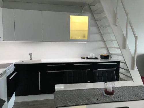 索特Näköalahuoneisto 426的厨房配有黑白橱柜和楼梯