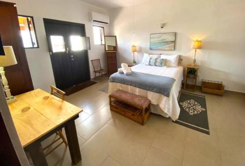 圣胡安KASA Charming Luna 2 bedroom的一间卧室配有一张大床、一张桌子和一张桌子。