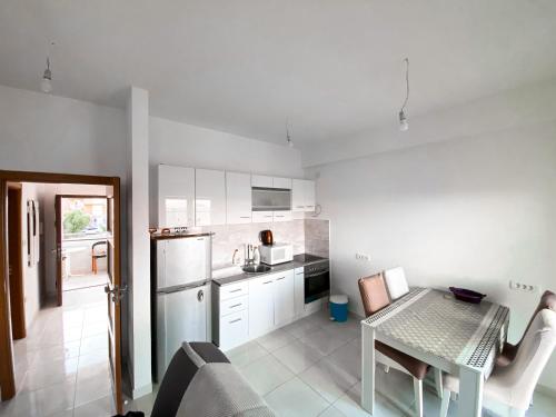 比耶拉Apartmani Mili的厨房配有白色橱柜和桌子