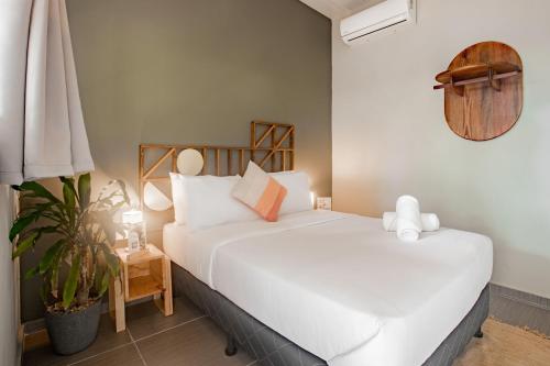 普拉纳维瑙Selina River Venao的卧室配有白色的床和植物