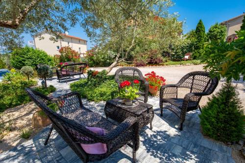 马林斯卡Apartment Skaline的庭院配有椅子和鲜花桌子