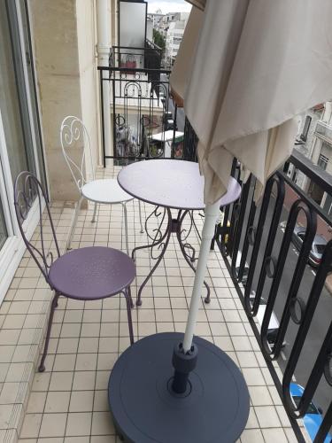 沙朗通勒蓬Appartement cosy de centre ville的阳台配有桌椅和遮阳伞
