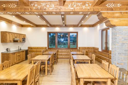 恰萨纳格拉Willa Taterniok - pokoje z widokiem na Tatry的用餐室配有木桌和椅子