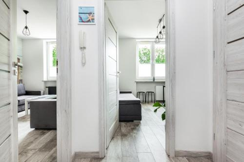 格丁尼亚Apartament Nadia的走廊设有白色的墙壁和木地板
