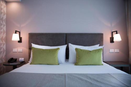 布宜诺斯艾利斯Howard Johnson Plaza Buenos Aires的一间卧室配有一张带绿色枕头的大床