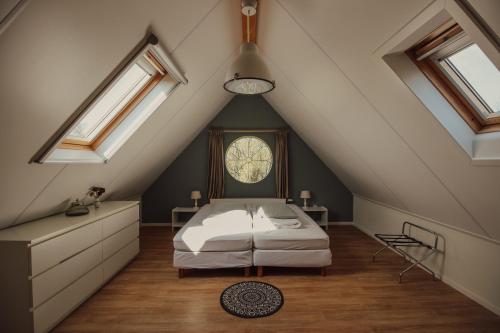 勒特朗舍芒de Kafzolder的阁楼卧室配有一张床和天窗