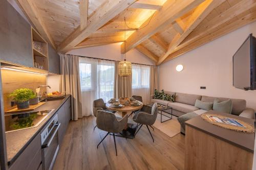 布鲁克安德格罗斯哥Lenni´s Apartments的厨房以及带桌子和沙发的客厅。