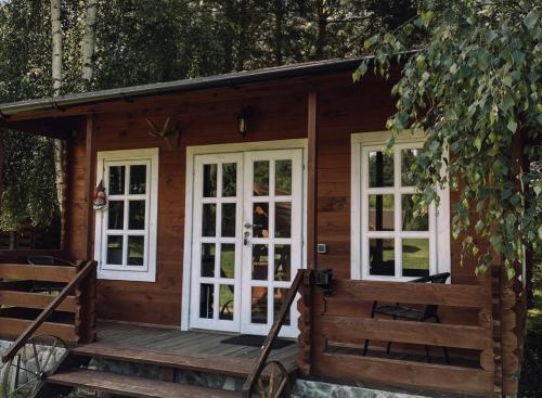阿尼克什奇艾Laumių Nameliai的小木屋设有白色窗户和门廊