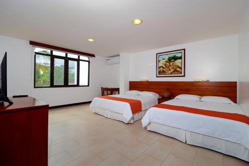 阿约拉港Galapagos Apartments - Bay View House的酒店客房设有两张床和电视。