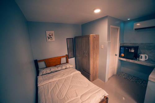 卢塞纳HK Hotel Kbartolo的一间卧室配有一张床和一个木制橱柜