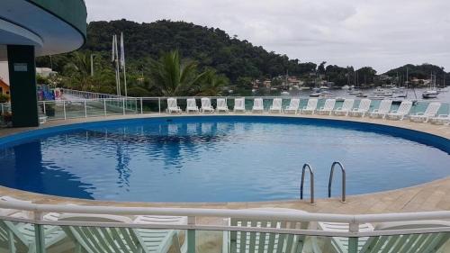 安格拉杜斯雷斯Angra Inn - Praia Grande 318的一个带椅子的大型游泳池,码头