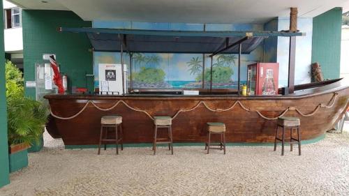 安格拉杜斯雷斯Angra Inn - Praia Grande 318的鱼缸前带凳子的酒吧