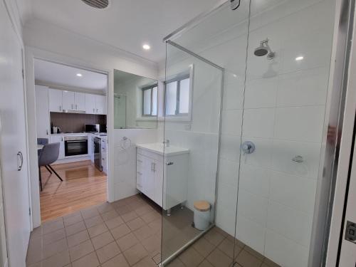 杰斯蒙Prickly Pear Stays Jesmond - Short Term Accommodations的一间带玻璃淋浴间的浴室和一间厨房