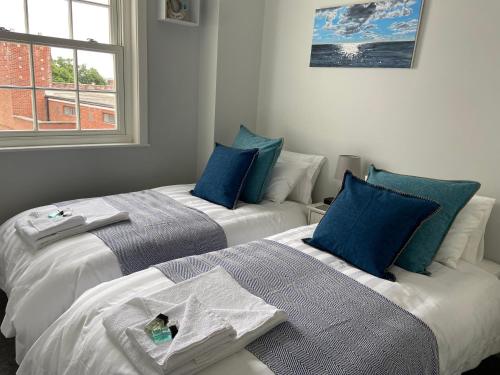 利明顿Solent Haven, Lymington with sea views and parking的两张睡床彼此相邻,位于一个房间里