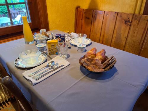 尚佩克斯 尚佩克斯欧维耶酒店的一张桌子,上面放着一盘面包和一篮糕点