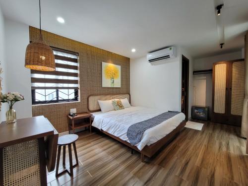 岘港Wings House的一间卧室配有一张床、一张桌子和一张书桌