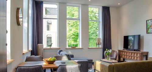 洛珀瑟姆Spoorzicht Long Stay Apartments的带沙发、椅子和窗户的客厅