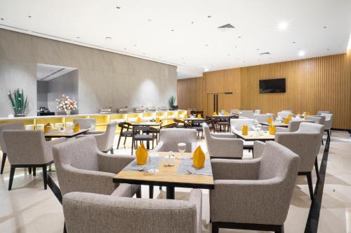 坤甸坤甸金色郁金香酒店的一间带桌椅和电视的餐厅