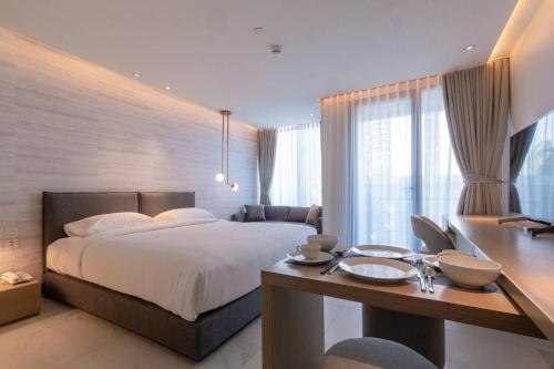曼谷Ashley Hotel BKK的一间卧室配有一张大床和一张书桌