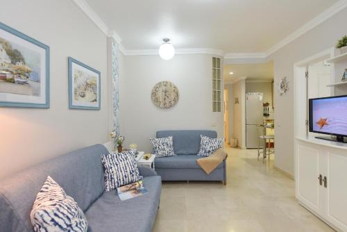 大加那利岛拉斯帕尔马斯拉斯坎特拉斯海滩公寓的客厅配有蓝色的沙发和电视