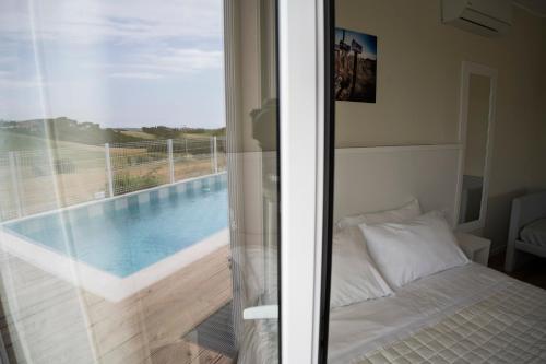 努马纳Balconi Del Conero的一间卧室,配有一张位于游泳池旁的床