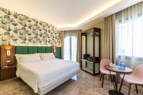 特罗佩阿Solmaris Tropea Rooms & Suites的卧室配有一张床和一张桌子及椅子