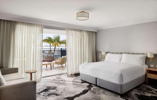 图克雷The Beachcomber Hotel & Resort, Ascend Hotel Collection的卧室配有床、椅子和窗户。