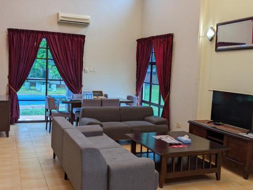 Kampong Alor GajahSerene Holiday Chalet with pool in a quiet enclave的带沙发和平面电视的客厅