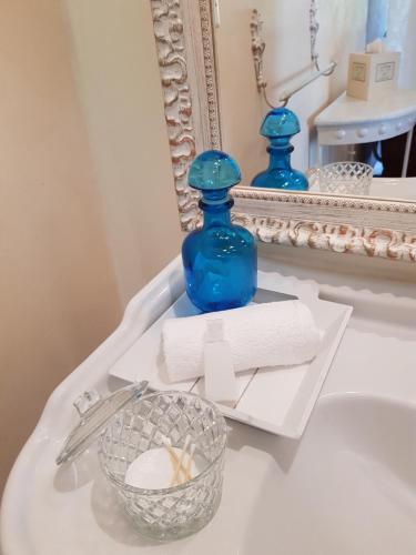 FongraveLe clos du Mûrier的浴室水槽上方的蓝色瓶子