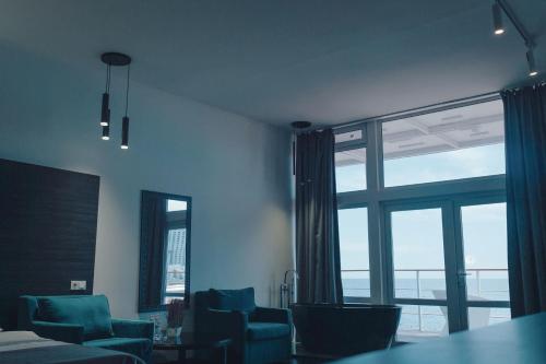 敖德萨Arkadia Beach Hotel的客厅设有蓝色椅子和大窗户