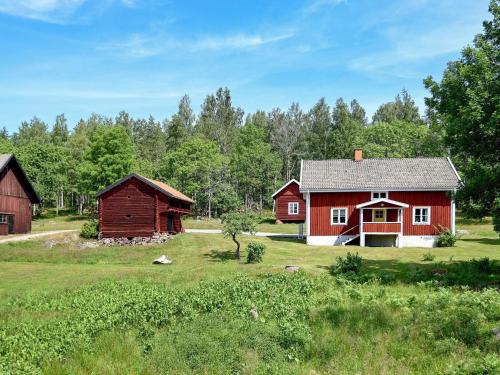 Hjortkvarn16 person holiday home in P LSBODA的田野中的红房子和谷仓