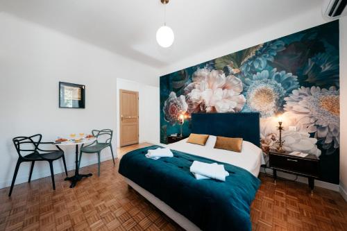 阿维尼翁Les Précieuses Suites & Spa II的卧室配有一张大床,墙上挂有绘画作品