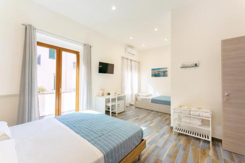 普罗奇达Lo Scuncino的白色的卧室设有床和窗户