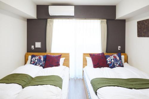 东京SG Premium KASAI的带窗户的客房内的两张床