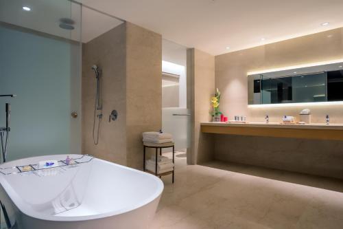 钦奈羽毛钦奈拉达酒店的带浴缸、淋浴和盥洗盆的浴室