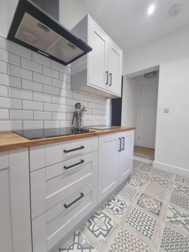 巴罗弗内斯Highly Modern home, 3 bed, close to the Lake District的厨房配有白色橱柜和瓷砖地板。