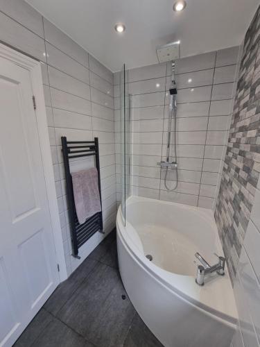 巴罗弗内斯Highly Modern home, 3 bed, close to the Lake District的白色的浴室设有浴缸和淋浴。