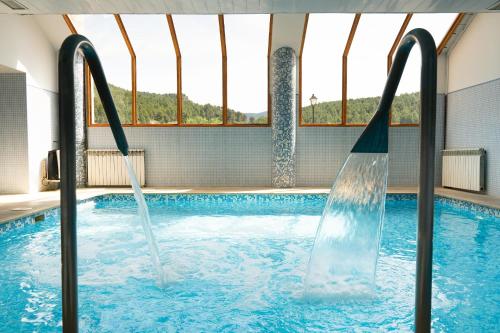 蒙塔尼约斯肖恩酒店的一个带水滑梯的室内游泳池