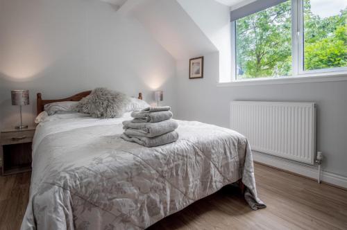 斯旺西Wern Y Glais - 2 Bedroom Cottage - Glais的白色卧室,配有带毛巾的床