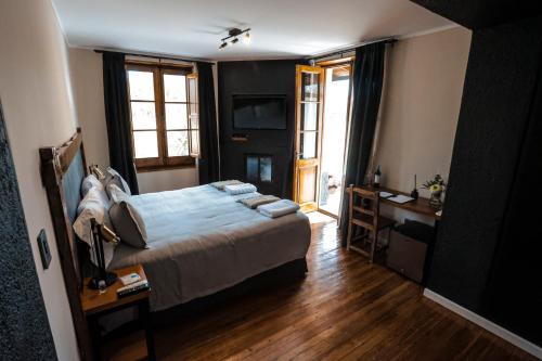 圣拉斐尔阿尔戈栋酒庄冠军俱乐部酒店的一间卧室配有一张床、一张书桌和窗户。